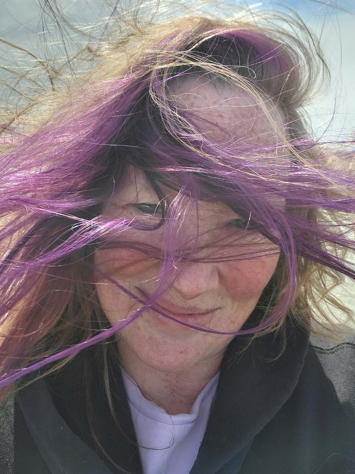 Deb Striker on the beach, hair wild in the wind