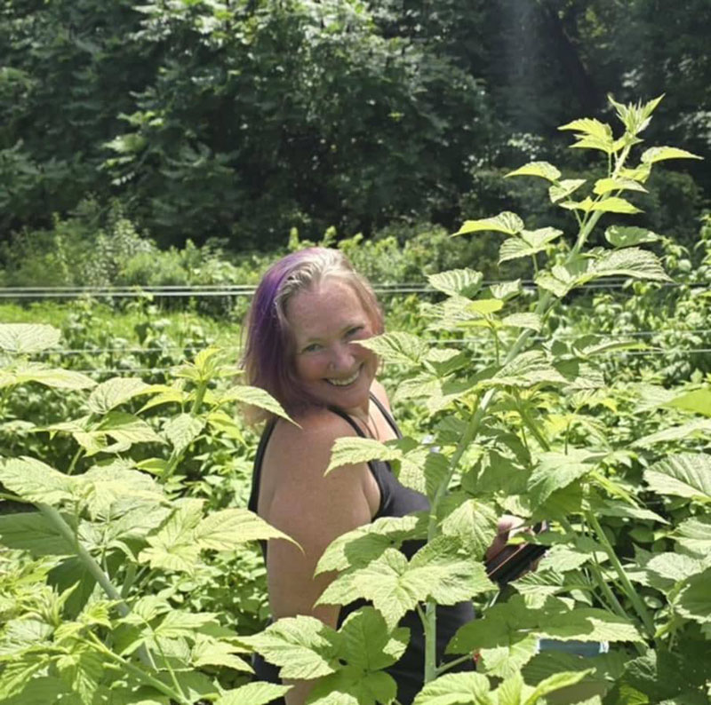Deb Striker smiling in berry bushes